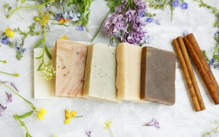 Natural handmade soap bars with organic medicinal plants, cinnamon spice and flowers.Homemade beauty products with natural essential oils from plants and flowers, top view closeup photoの写真素材