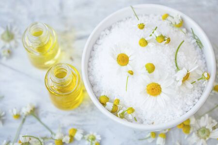 Spa still life with chamomile bath salt, oil bottles and flowers, natural beauty and skincareの写真素材
