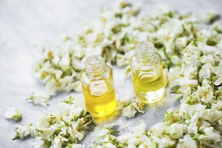 Jasmine essential oil bottles with dried jasmine flowersの写真素材