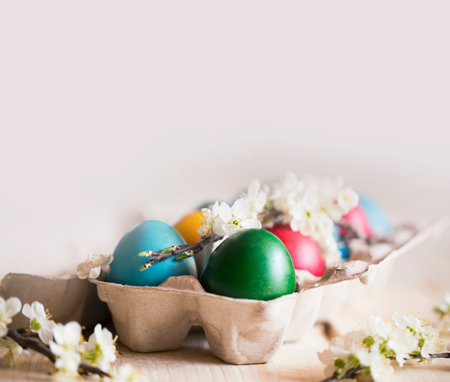 Red Easter eggs with spring blossoms, natural painted festive Easter eggs with white spring flowers...