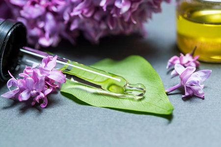 Glass bottle of Lavender essential oil with fresh lavender flowers on wooden table, aromatherapy spa massage concept. Lavendula oleumの写真素材