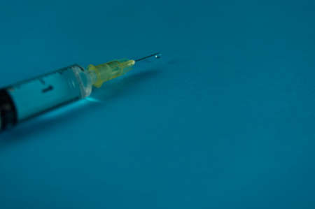 A syringe with liquid drop on blue backgroundの写真素材