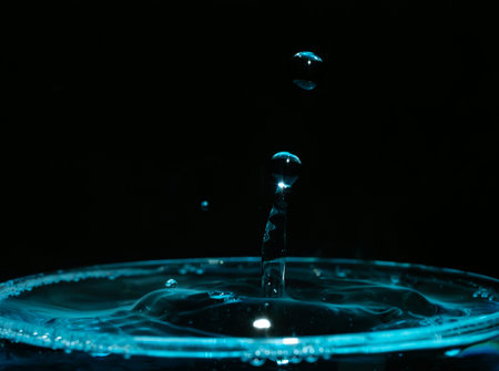 Water drop closeups while drops falling down and splashing into water