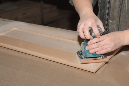 manual polishing of wooden furniture of a facade made of solid beech wood in joineryの写真素材