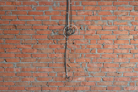 several electrical cables on a brick wall for future installation of outlets in a newly built house without people in the backgroundの写真素材