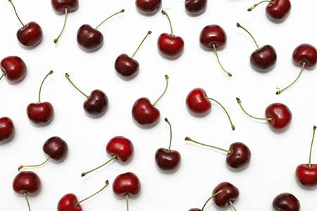 pattern ripe delicious cherries scattered in a chaotic order on a white background without people background imageの写真素材