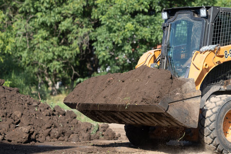 yellow excavator collects earth in a big pile without people