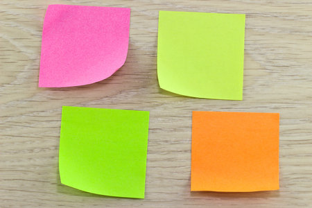 Four colored stickers on wooden background
