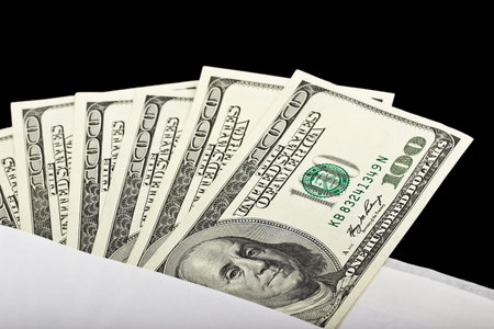 US dollars in an envelope on a black background