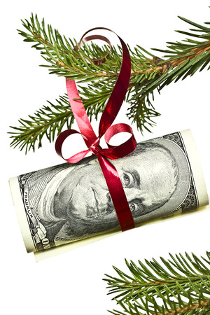 dollar banknote hanging on christmas tree branch on white backgroundの写真素材