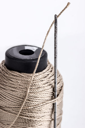 Old rusty sewing needle and thread