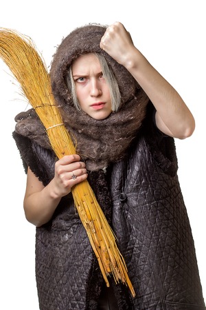 Angry young woman showing fist,  with a broom in his hand on white backgroundの写真素材