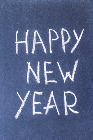 Happy New Year written in white chalk on a black chalkboardの写真素材