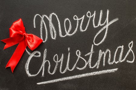 Merry Christmas written in white chalk on a black chalkboard isolated on whiteの写真素材