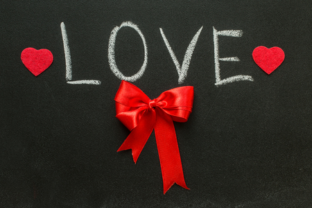 the word love and red bow on the chalkboard. Valentine's Day Conceptの写真素材