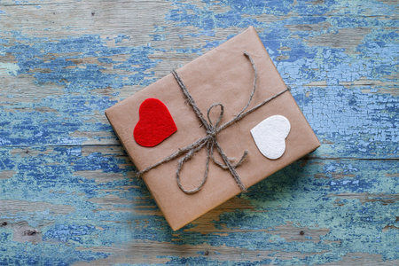 Gift box with hearts on wooden background with crackling effect. Valentine's Day Concept
