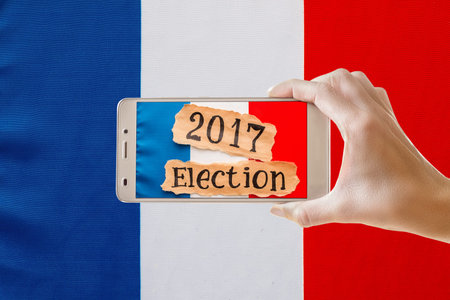 Elections in France.  Female hand holding mobile smart phoneの写真素材