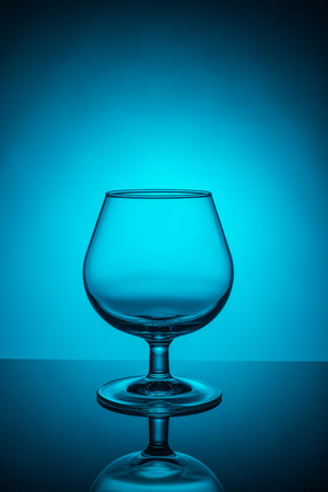 Empty wine glass on a blue colored backgroundの写真素材