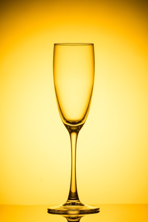 Empty wine glass on yellow background.の写真素材