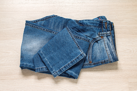 New blue jeans on wooden background top viewの写真素材