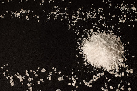 Salt on a black chalkboard,  top view, selective focus