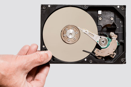 Hand holding a hard disk drive. isolate on gray background