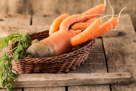 Fresh Organic Carrots in a basket on wooden background, rustical, selective focusの写真素材