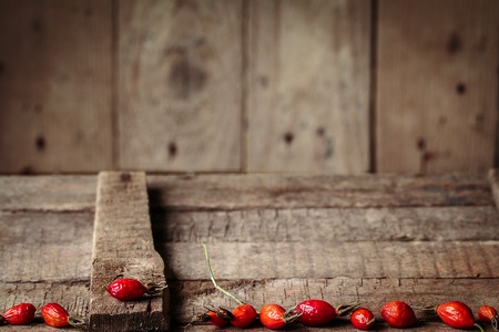 berries of a dogrose on a wooden tableの写真素材