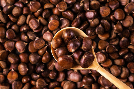 Roasted chestnuts on a wooden spoon. Fresh sweet chestnut. Food background.の写真素材