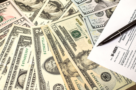 Calculating numbers for income tax return with pen and calculatoの写真素材