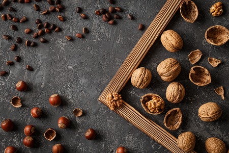 Different nuts on stone table. Cedar, hazelnut, walnuts.の写真素材