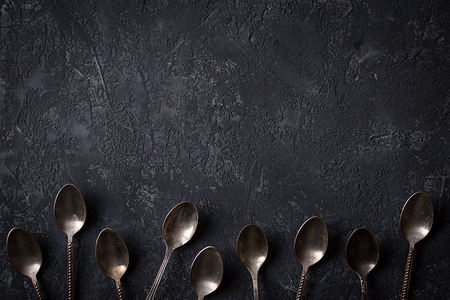 Old vintage spoons on stone table. Top view.の写真素材