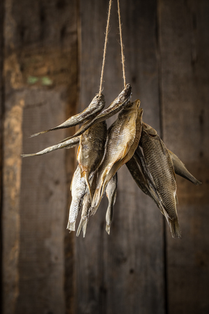 Dried fish on old boards.  Food background on woodの写真素材