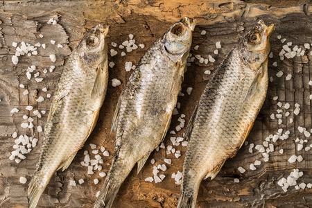Dried fish lies on rustic kitchen table background.の写真素材