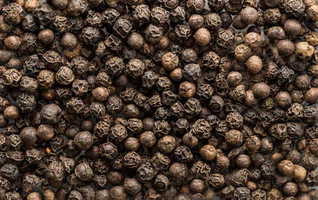 Black pepper seeds as background texture. Organic food, healthy lifestyle, space for text. Top view,...