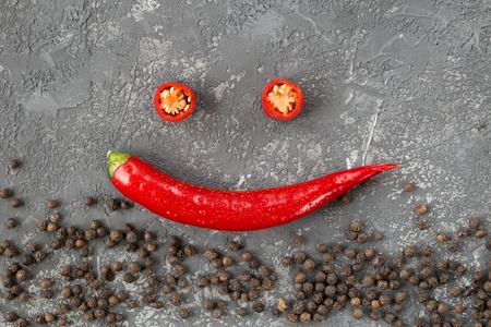 Fresh Chili pepper and peppercorns over gray stone background. Raw organic spices. Healthy lifestyle.  Top view with copy space.  culinary backgroundの写真素材