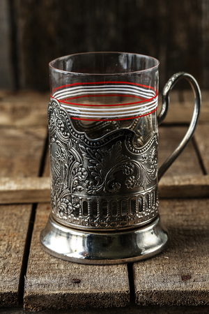 Vintage empty glass for tea with cup holder on rustic background. Old kitchen utensils, selective focusの写真素材