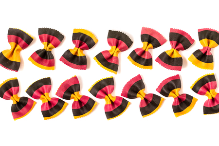 Uncooked colored farfalle pasta on white background. Diet and food concept.の写真素材