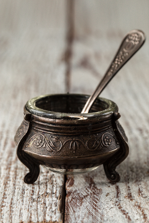 antiques silver saltcellar on rustic kitchen table. Old kitchen utensils, selective focusの写真素材