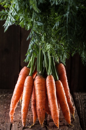 Bunch of carrots on rustic  table.  Vegetables harvest.の写真素材