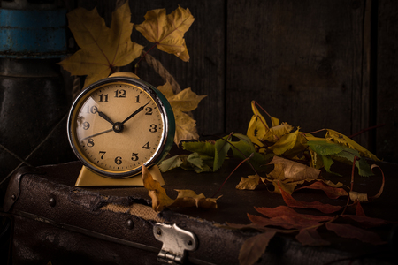 Romantic autumn still life with books, vintage suitcase,  old clock and leaves. Vintage still lifeの写真素材