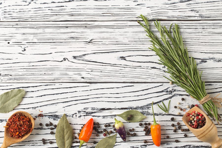 background rosemary, chili pepper on a wooden table. Herb and spice ingredients on  wooden white...