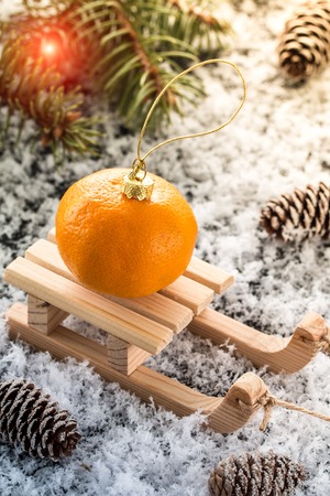 Christmas card with wooden sled,  with  fresh tangerine over old wooden background.  image with selective focusの写真素材