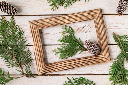 Christmas decoration on the white wooden background. Christmas interior with photo frame, decorative branches on wooden table. New Year winter composition. Top View. Space for textの写真素材