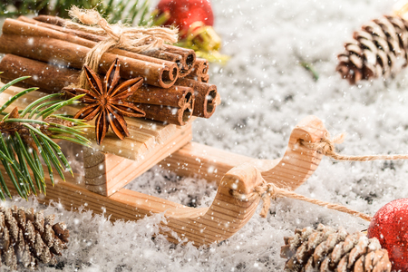 Christmas card with wooden sled with heap of cinnamonの写真素材