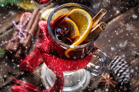 Christmas mulled red wine with spices and oranges on a wooden rustic table. Traditional hot drink at Christmasの写真素材