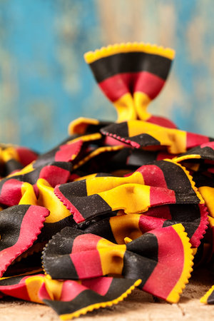 Italian raw multicolored farfalle pasta closeup on the table.
