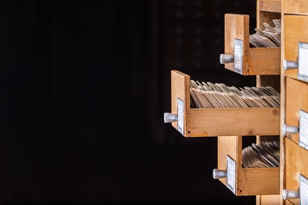 Library or archive reference card catalog. Database, knowledge base concept. Old library or archive reference catalogue with  opened card drawerの写真素材