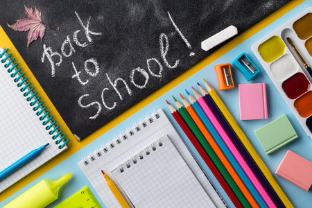 Colorful School stationery and chalkboard on colorful background. Creative flat lay back to school...