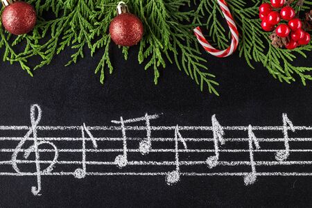 Musical christmas background with fir branches and red festive decoration ballの写真素材